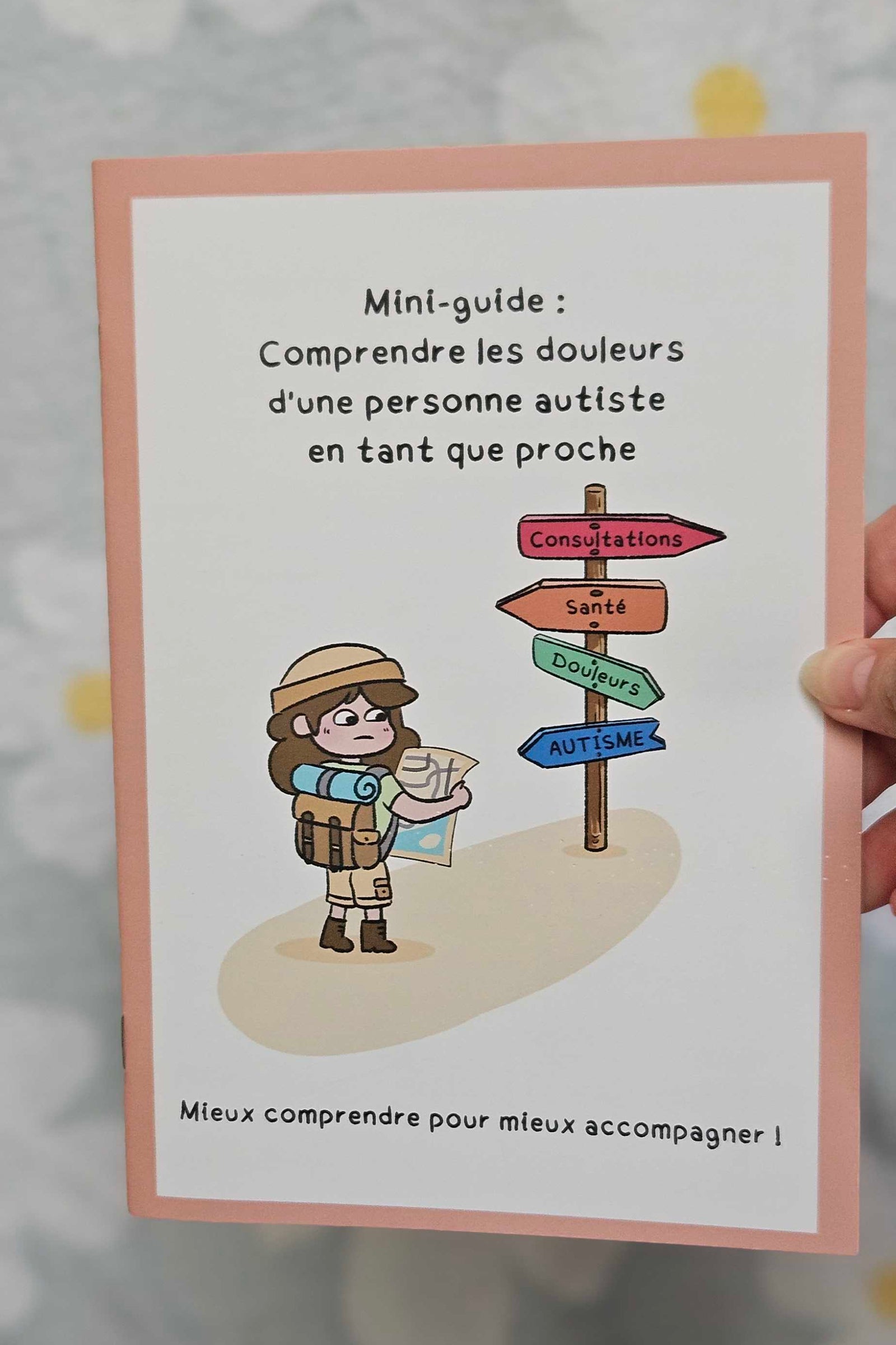 Couverture du mini-guide « Comprendre les douleurs d'une personne autiste en tant que proche », avec un personnage carte en main devant un panneau indicateur (consultations, santé, douleurs, autisme)